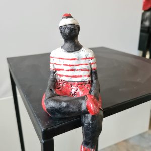 Petit marin en short rouge et blanc assis – Raku
