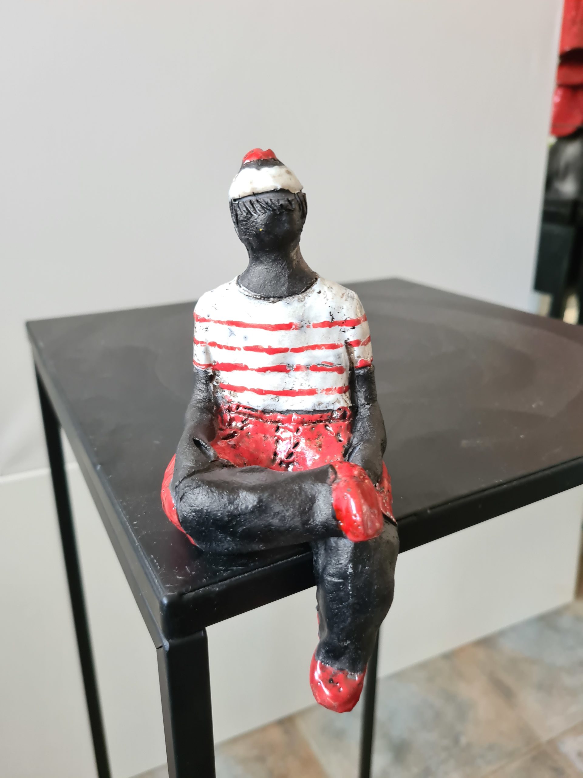 Petit marin en short rouge et blanc assis – Raku